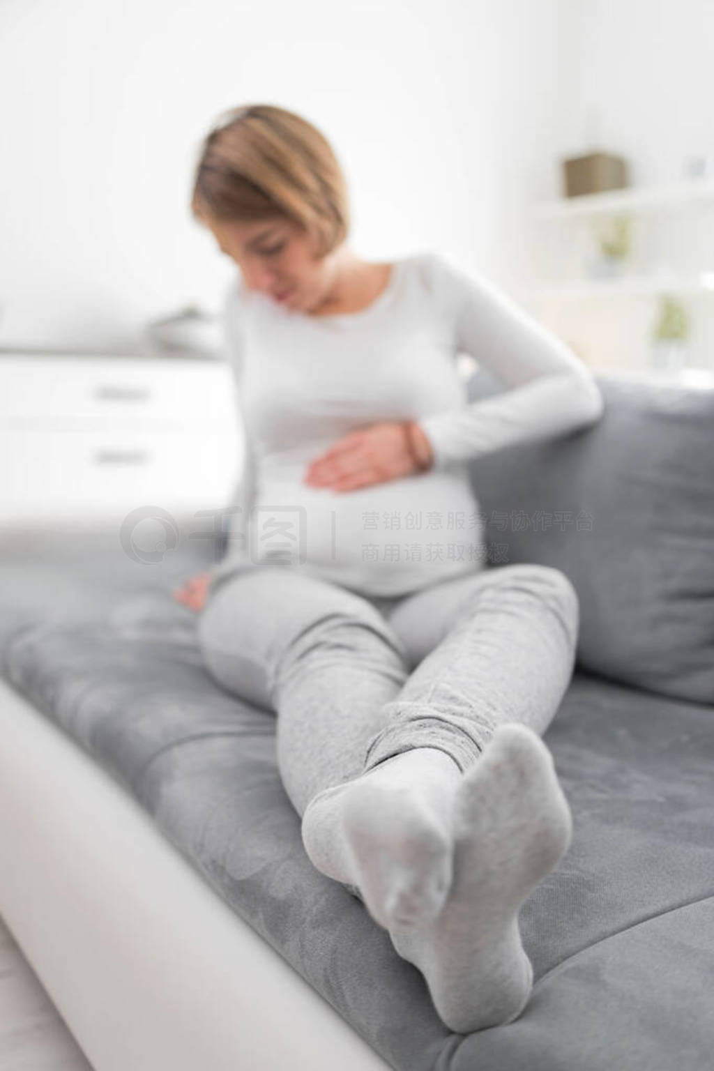 Pregnant tired exhausted woman with stomach issues at home on a