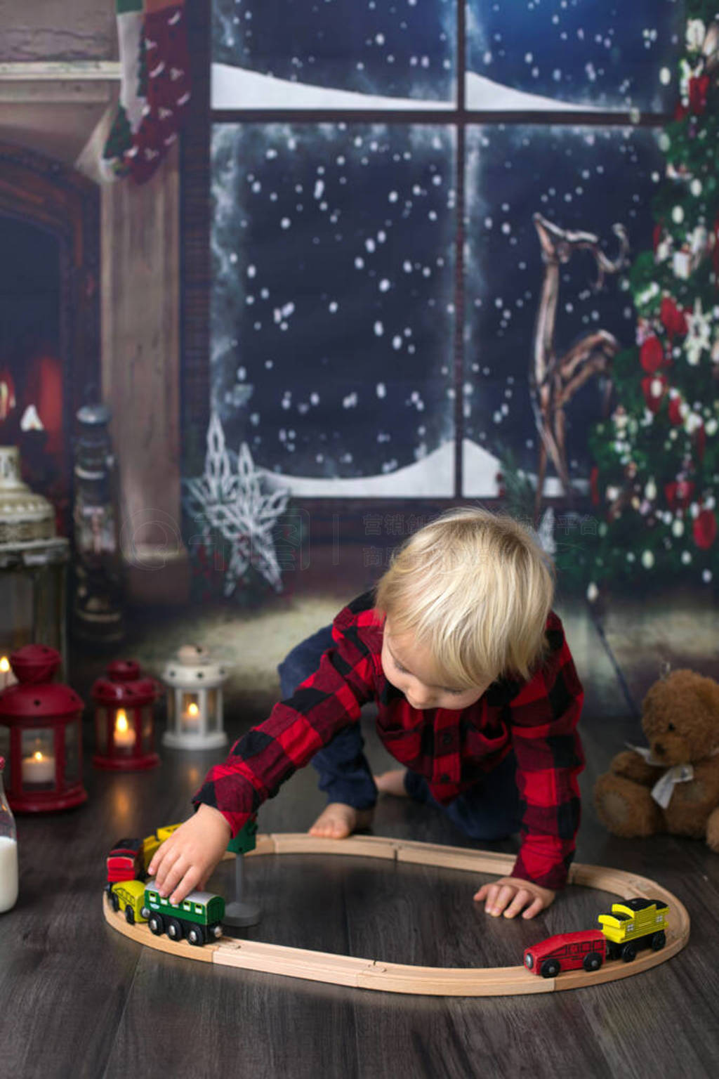 Sweet toddler boy,playing with wooden train at home at night on