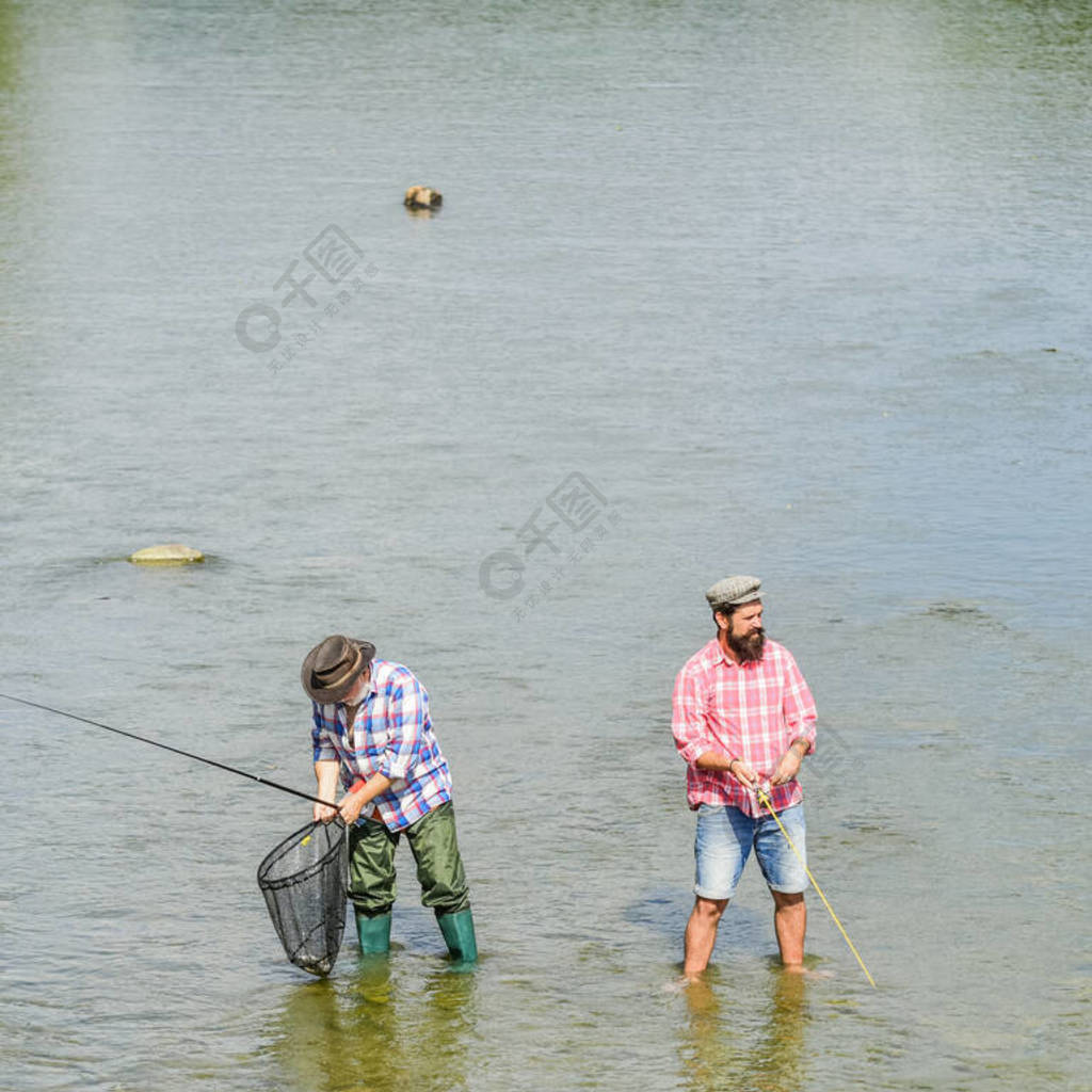 一起做。爱好体育活动。鳟鱼饵。两个快乐的渔夫拿着鱼竿和渔网。户外