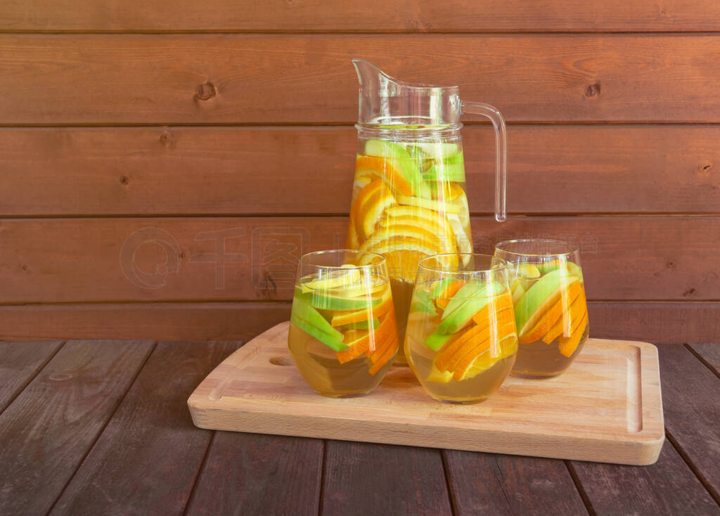 White wine sangria with fruits in glasses and pitcher on cutting