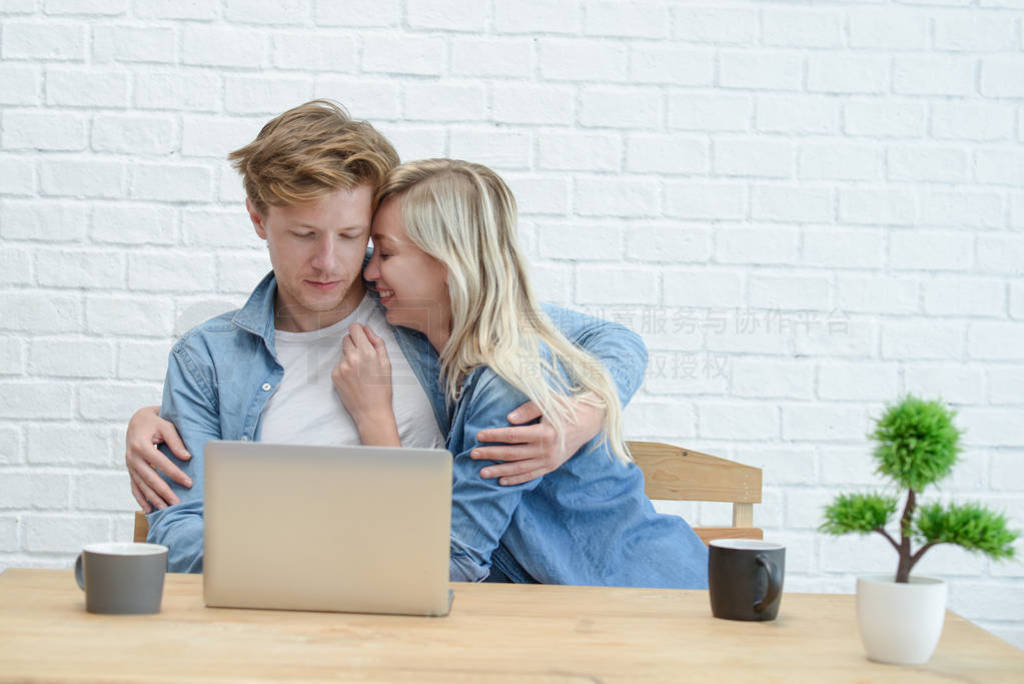 Young couple managing their family budget, sitting on the white