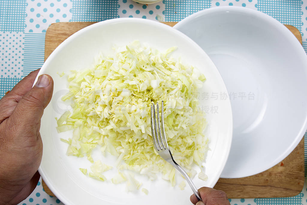 Chef putting Shredded cabbage to the bowl