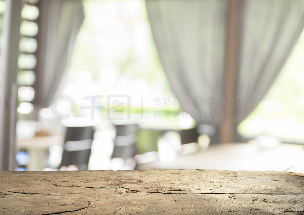 Empty of wood table top on blur of curtain with window view gree