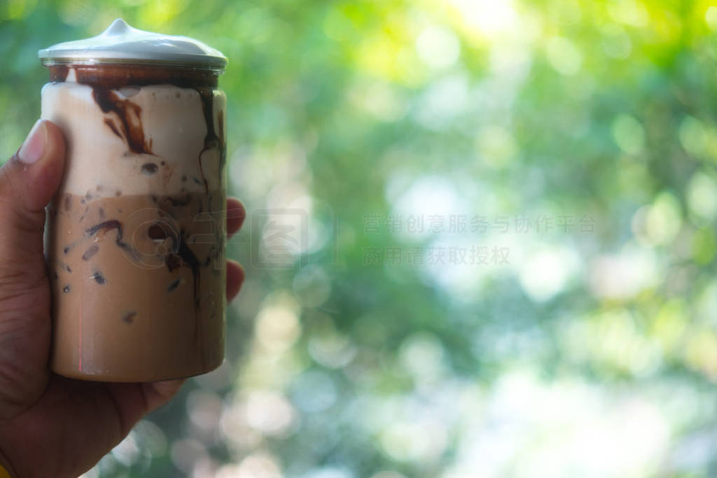 Hand holden iced mocha in clear plastic tin