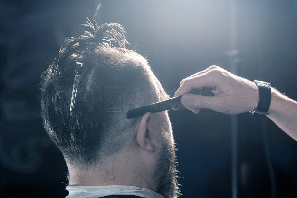 Barbershop. Hairdresser professionally performs a trend haircut