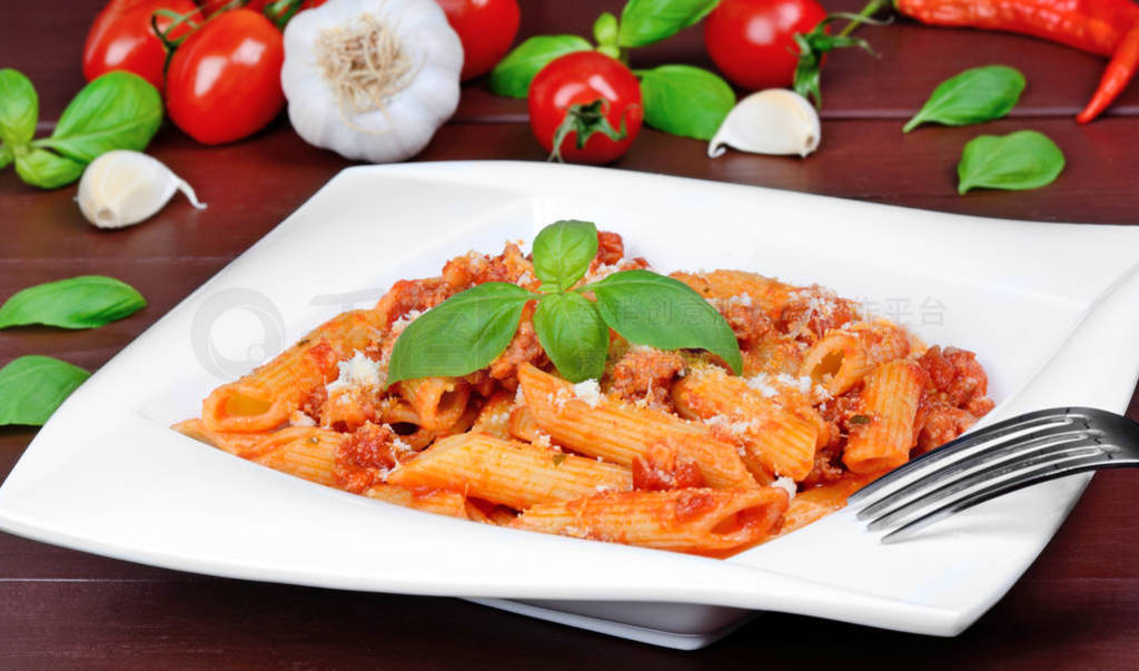 Pasta with tomato sauce,parmesan and basil in a plate on table