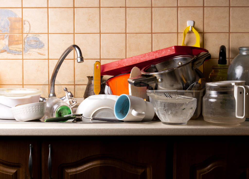 A lot of dirty dishes lie in the sink in the kitchen that needs