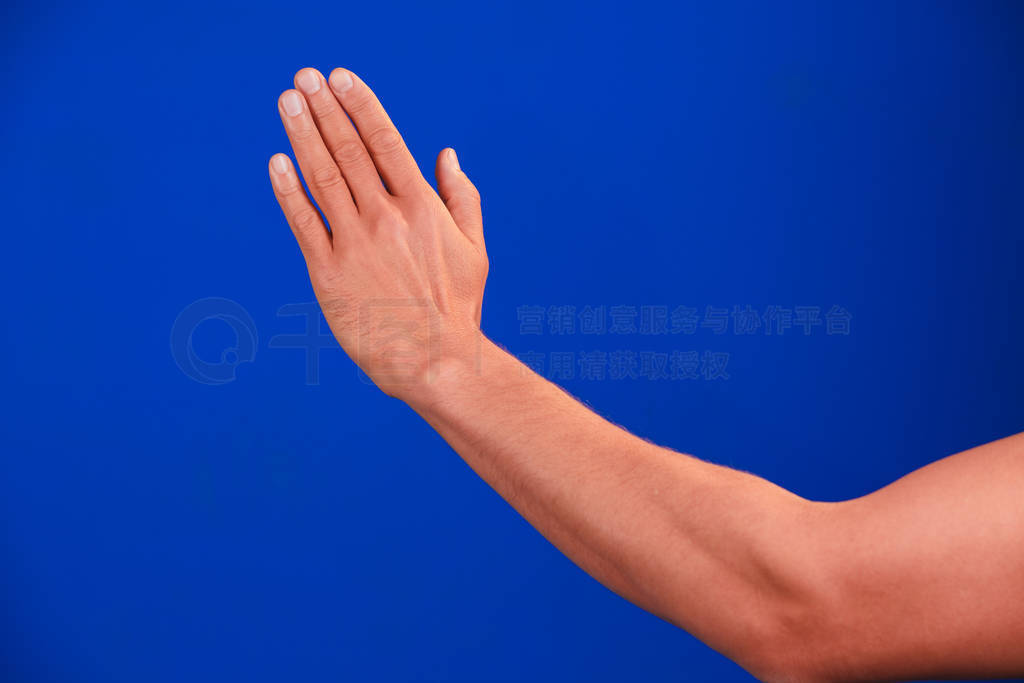 Human hand on blue background chroma-key.