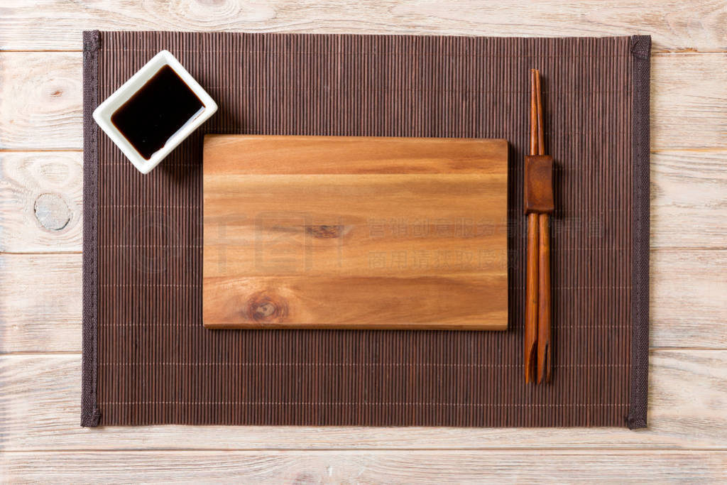 Empty rectangular wooden plate with chopsticks for sushi and soy