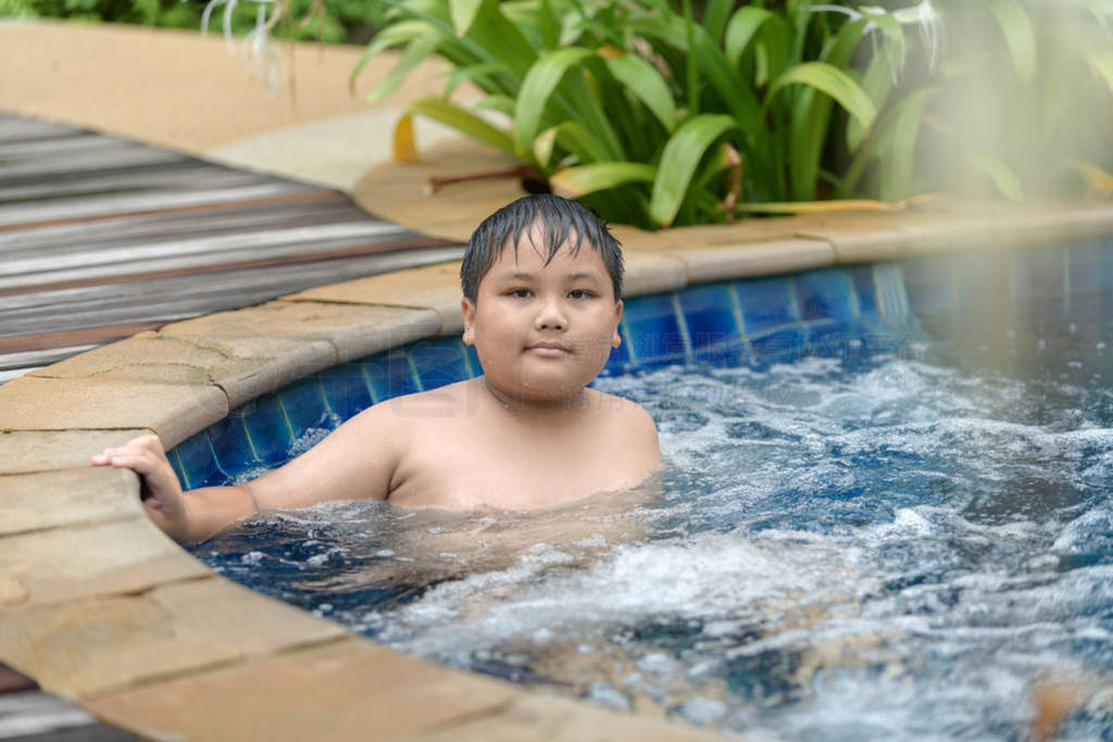 Obese boy relaxing enjoying hot tub bubble bath