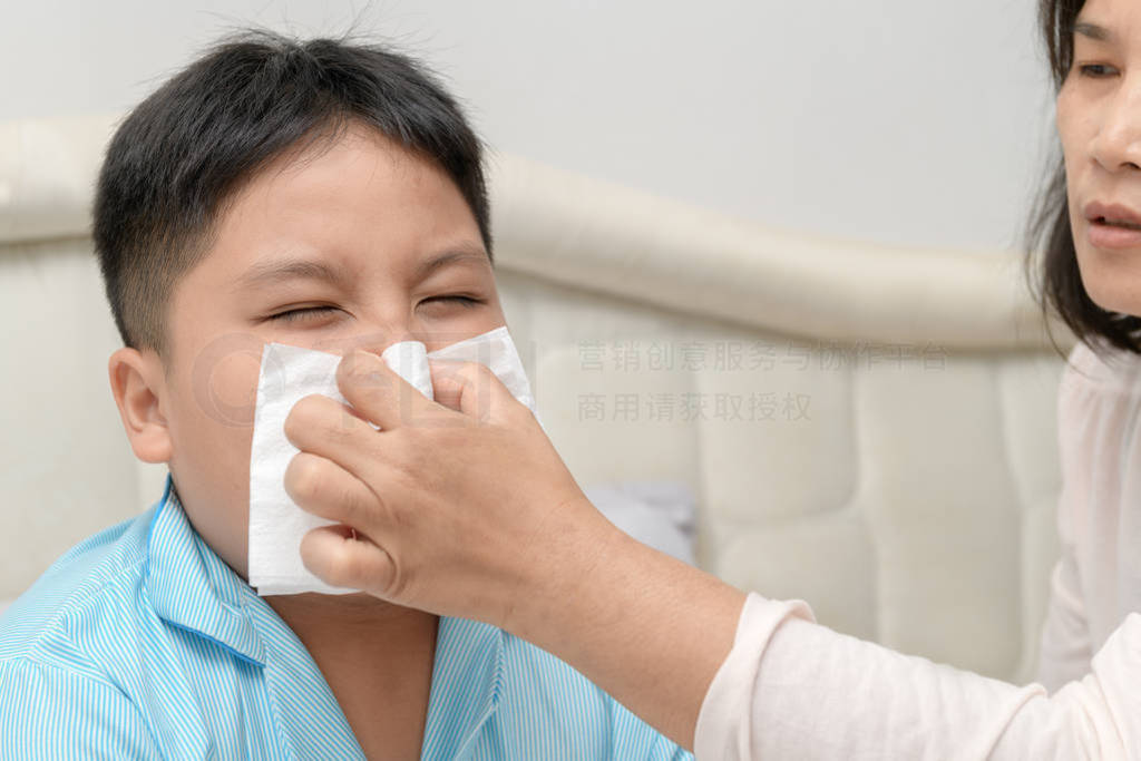 Sick asian child wiping or cleaning nose with tissue