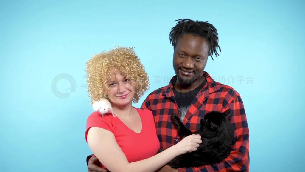 African male and a Caucasian woman . holding a black cat and a