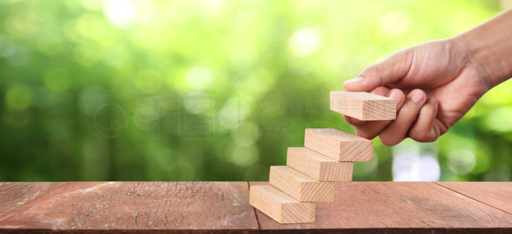Wood block in hand stacking as step stair. Business concept gro