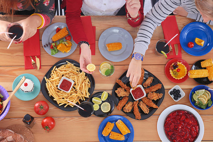 顶视图的一群人在一起时坐在木桌吃饭在桌子上的食物人们吃快餐