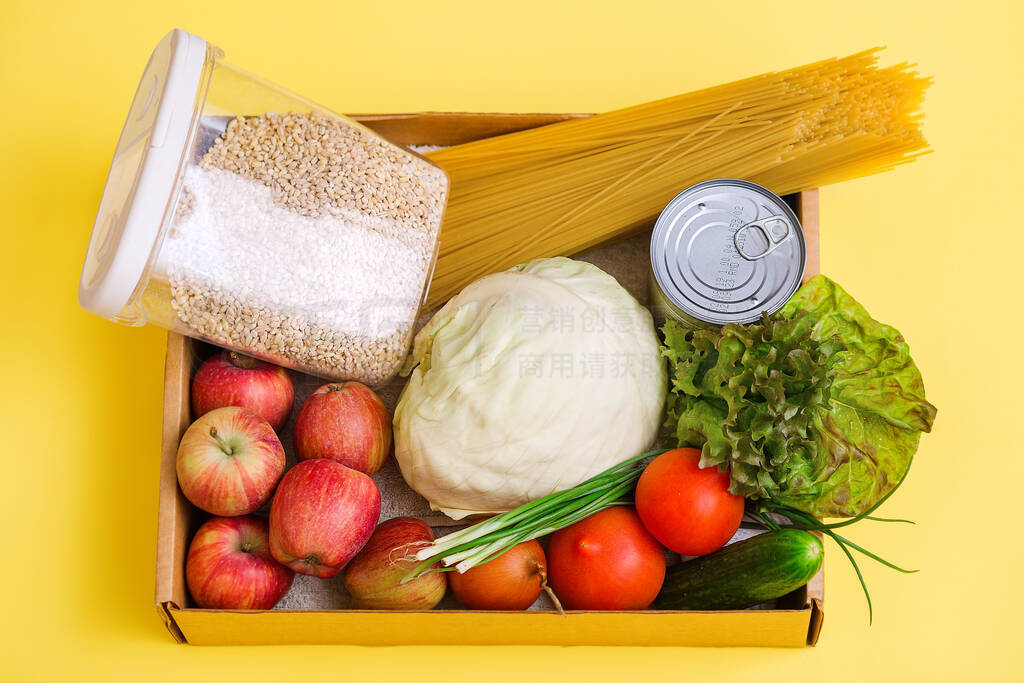 various food in a cardboard box and a donation sign on a yellow