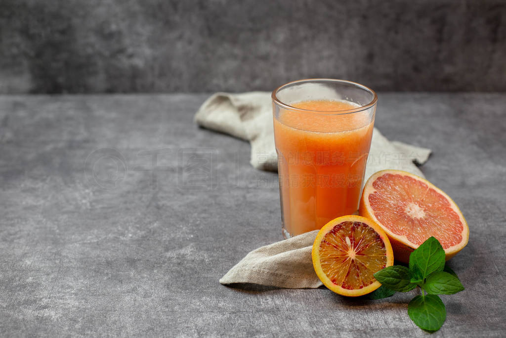 A glass of freshly squeezed grapefruit juice with fruits, with a