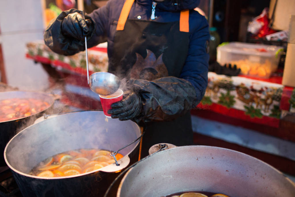 Hot gluhwein or mulled wine in a cauldron at fair, local treat,