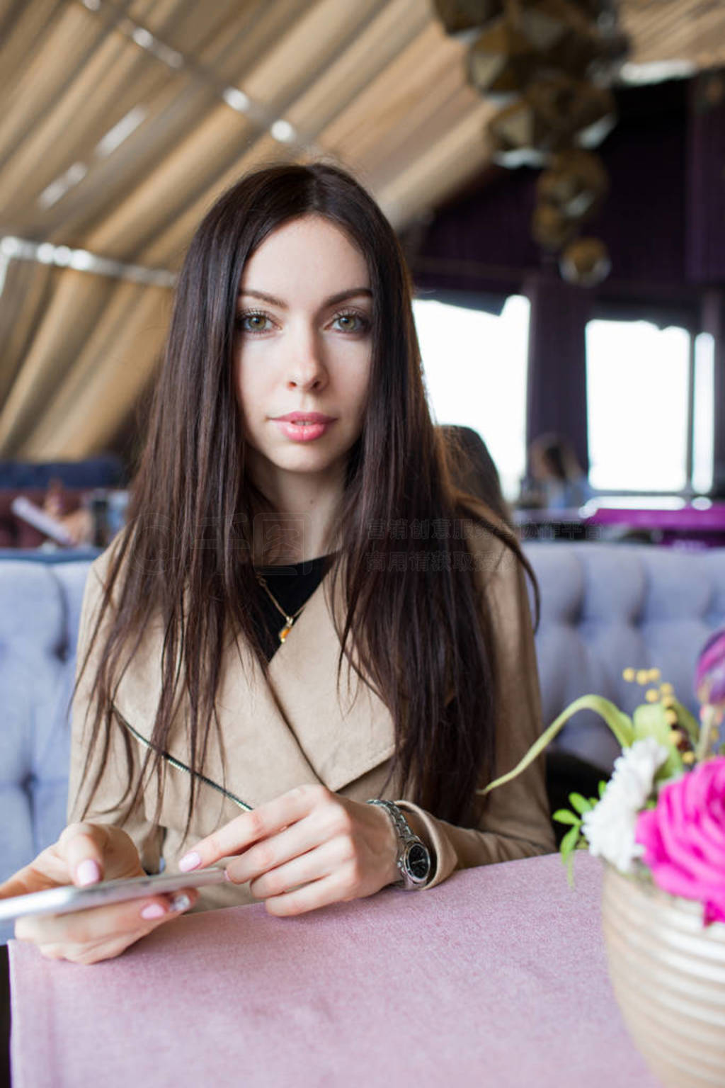 Beautiful girl in a cafe with a phone in her hands. Close-up, si