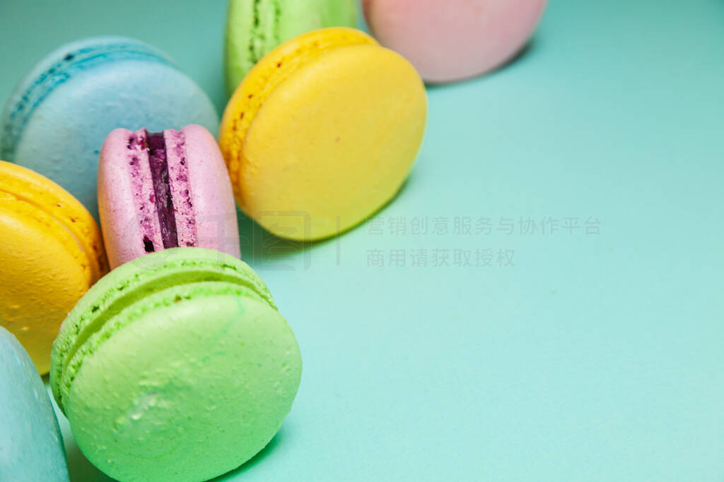 Different colorful macaroons on blue background. Free space for