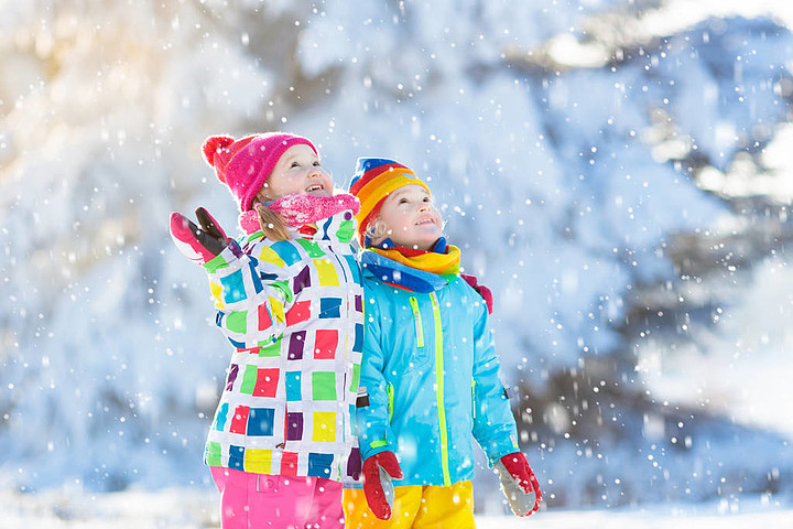 在下雪的冬天的一天,孩子在户外玩男孩和女孩抓雪花在降雪风暴