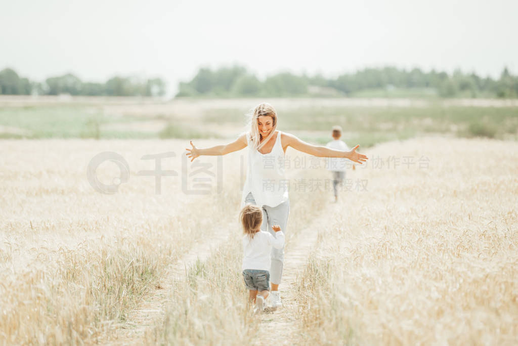 Happy mother and her children spending time together in sunny fi