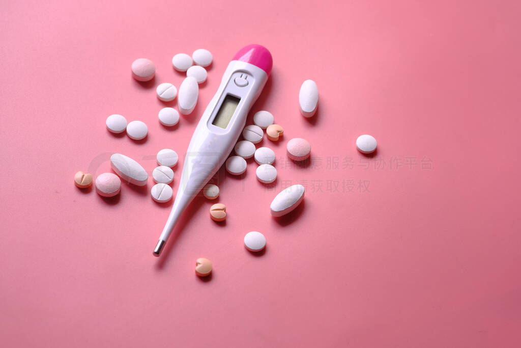 close up of pills , thermometer on pink background