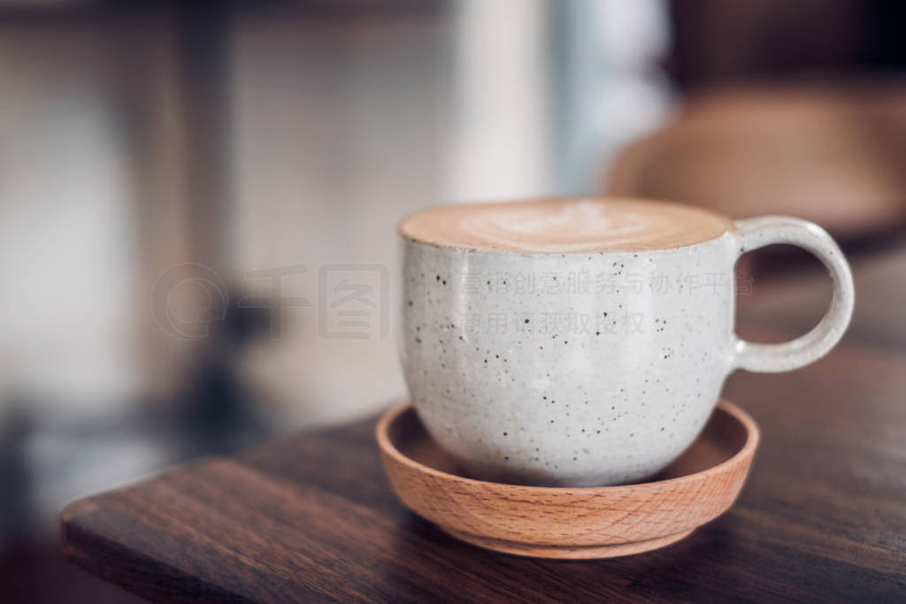 hot cappuccino coffee cup on wooden tray with latte art on wood