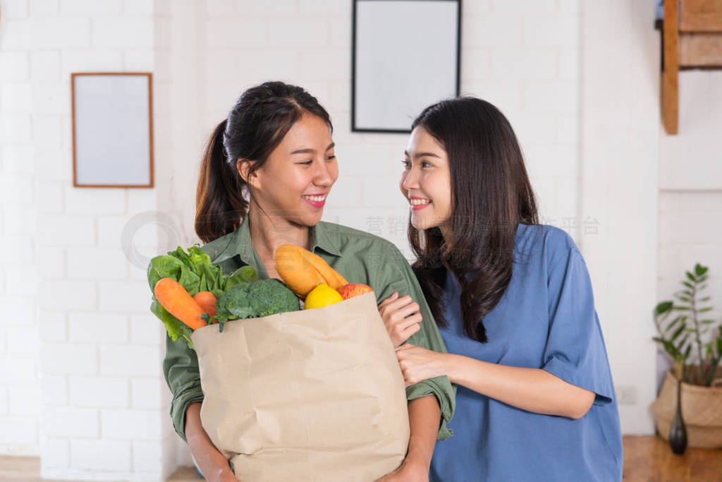 Happy asian couple lesbian holding vegetable bag after shopping