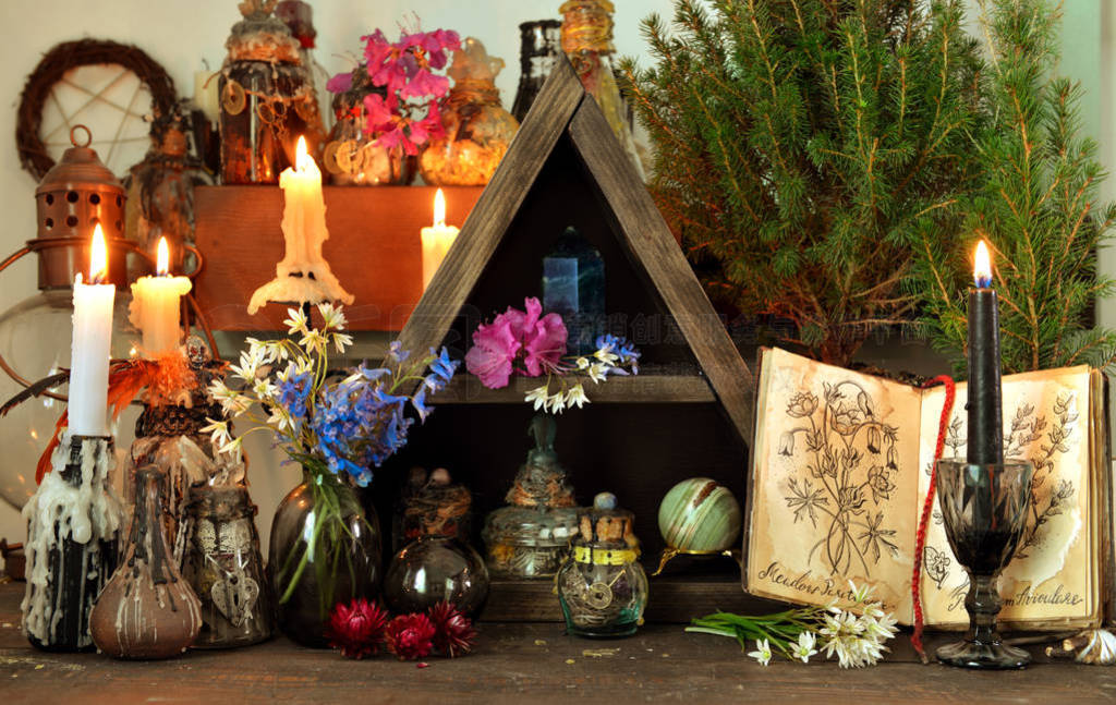 Witch altar table with magic book, flowers and spiritual objects