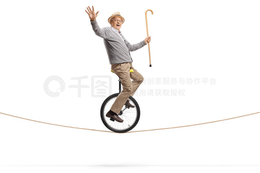 Elderly man riding a mono-cycle on a rope and holding a walking