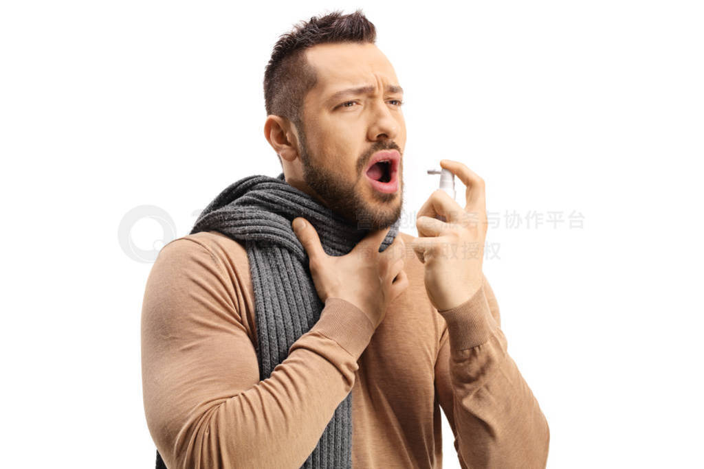 Young man spraying a medication in his throat