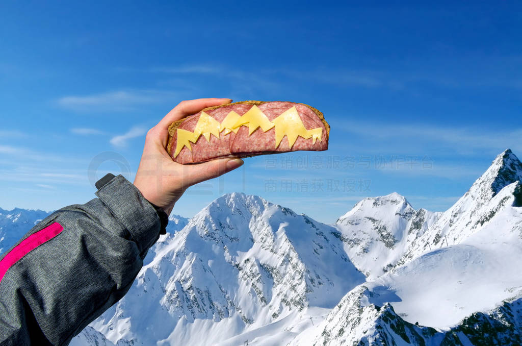 decorated sandwich with salami sausage and cheese, mountains as