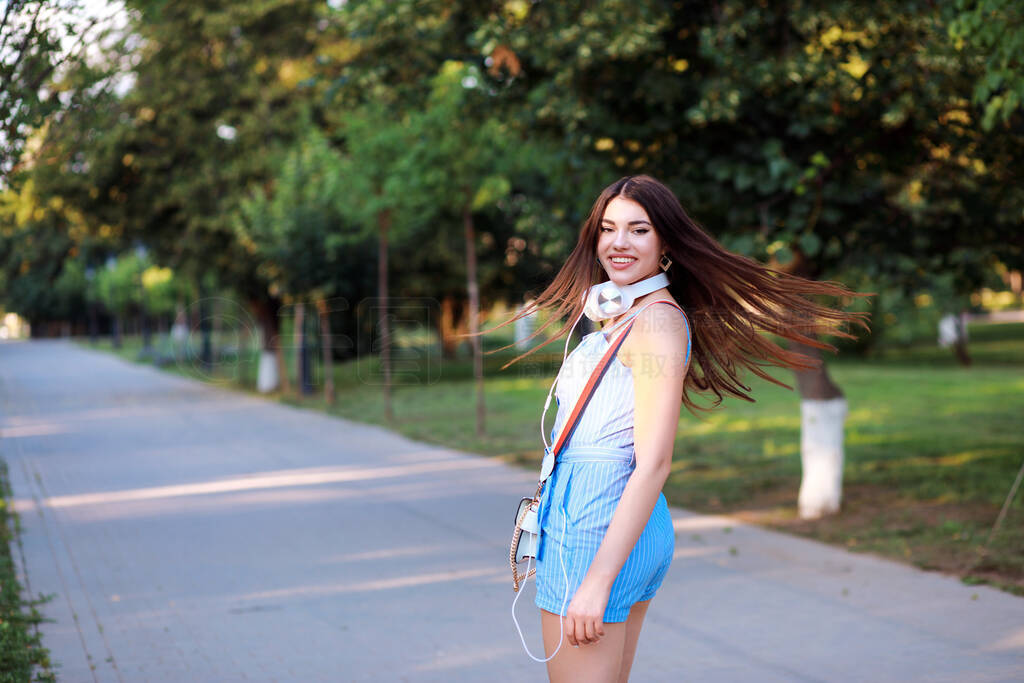 Beautiful stylish woman is spending time outdoors in the park, h