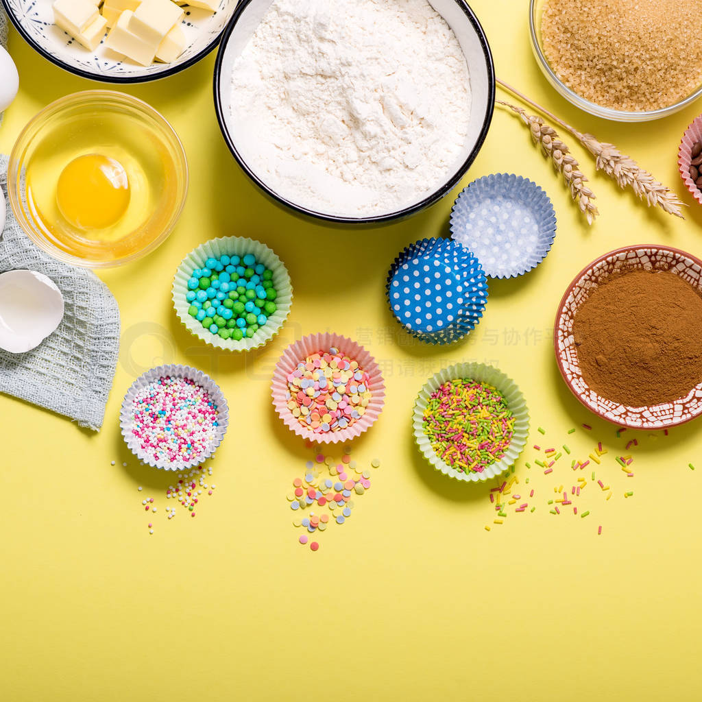 Baking ingredients for cupcakes or muffins on yellow copy space