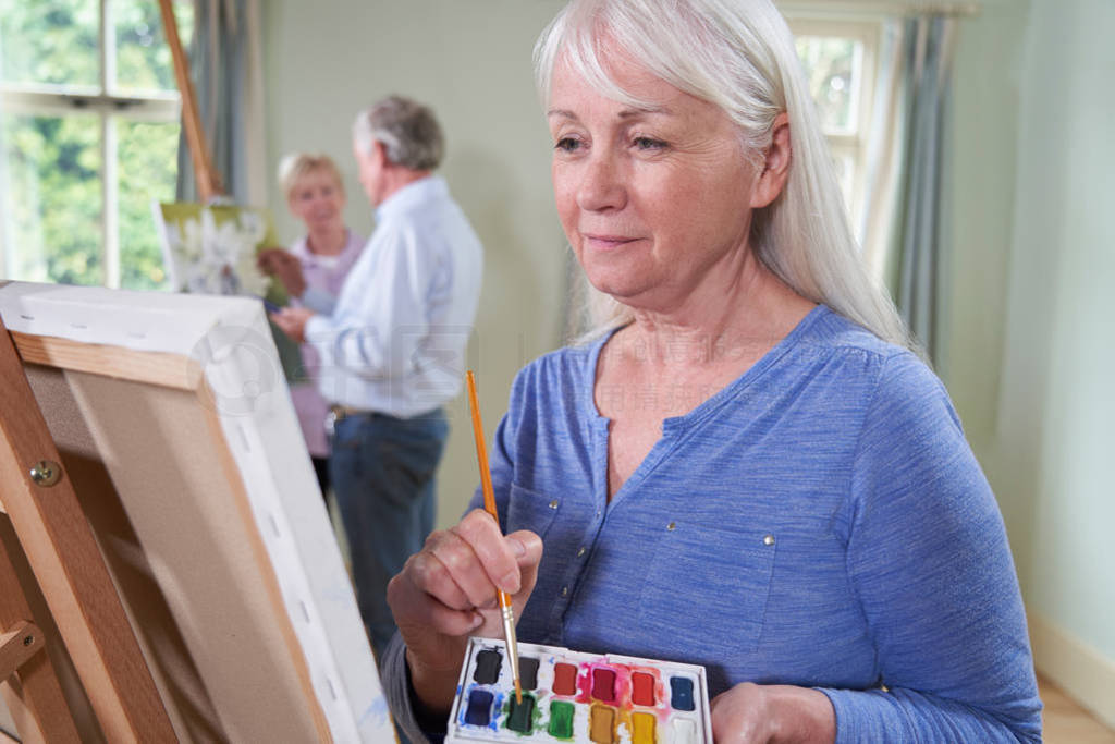 Group Of Seniors Attending Painting Class With Teacher