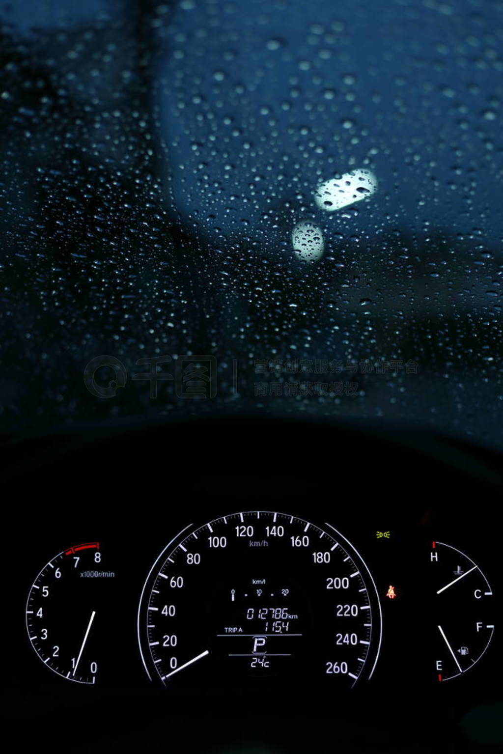 speedometer night light in modern vehicle car with rain drop on