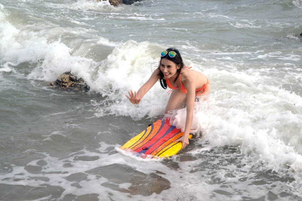 Pretty Asian woman in bikini with surf board on fun , Surfboard