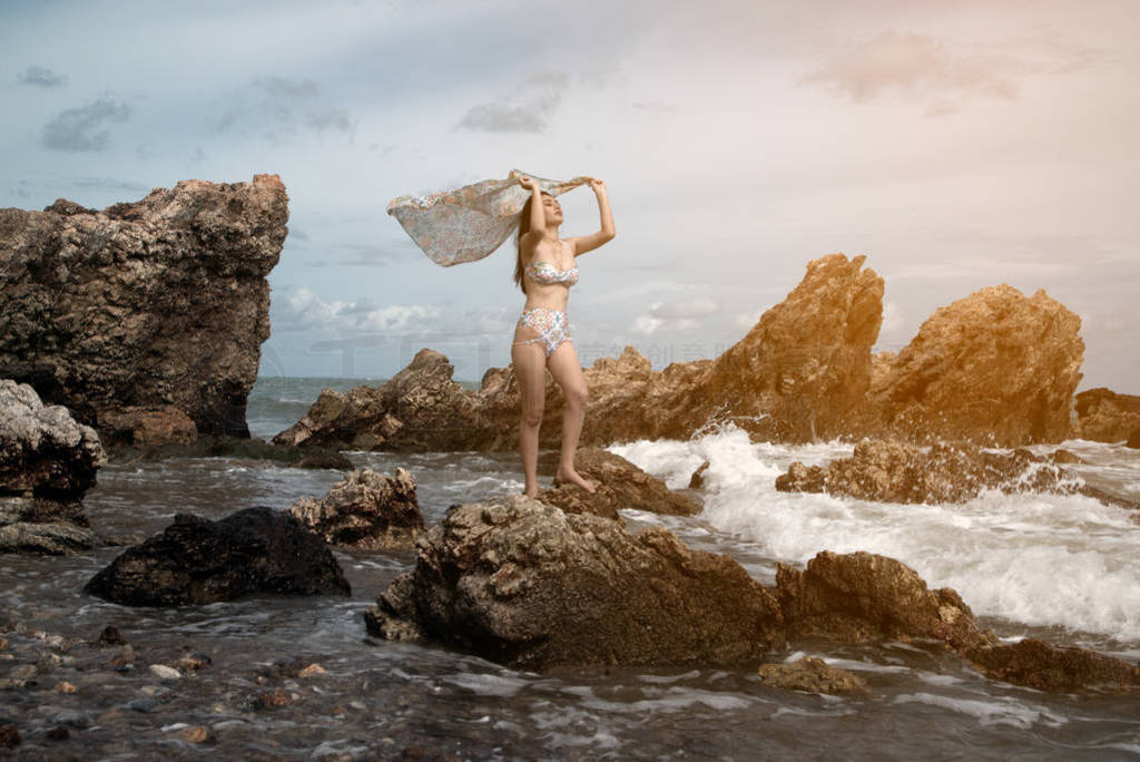 Pretty Asian female in a swimming suit standing and flaunt fabri