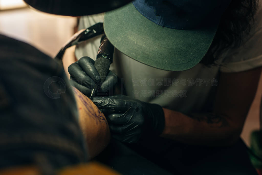 Close up of professional tattooer artist doing picture on hand o