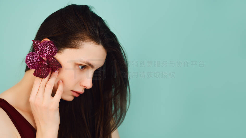 young girl with a burgundy flower on a turquoise background posi