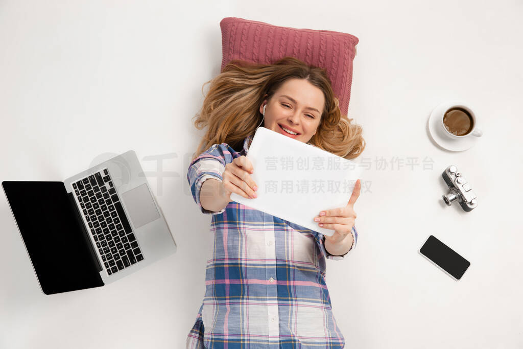 Emotional caucasian woman using gadgets isolated on white studio