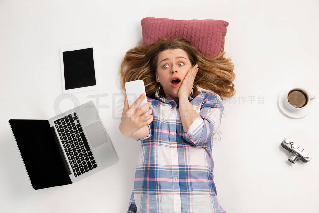 Emotional caucasian woman using gadgets isolated on white studio