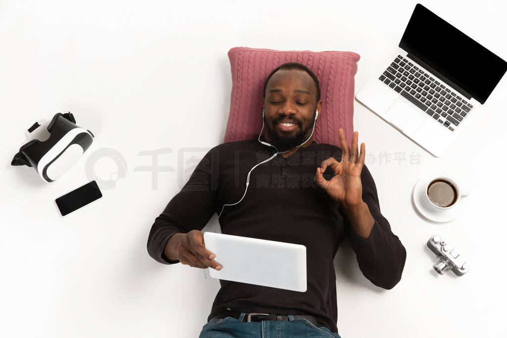 Emotional african-ameican man using gadgets isolated on white st
