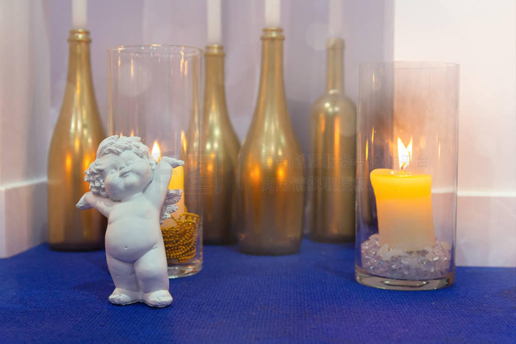 Candles in glass and angel statue for wedding ceremony