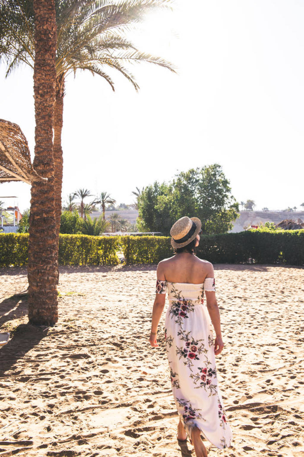 woman walking on beach while sunset