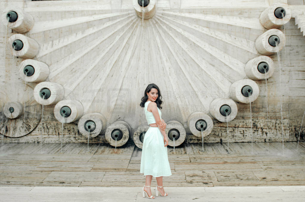 young woman in white dress outside posing and smiling