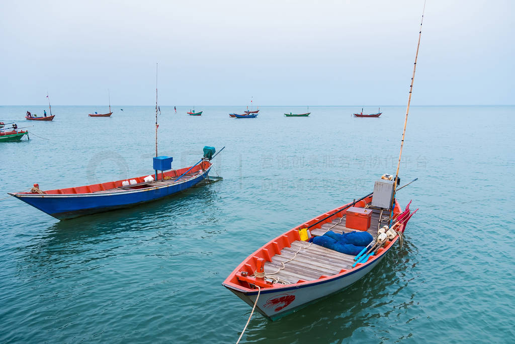 Floating fishing boats aground at the harbor over cloudy sky at