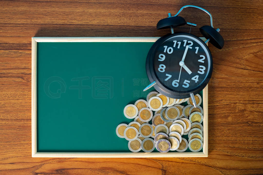 Alarm clock and step of coins stacks on working table, time for