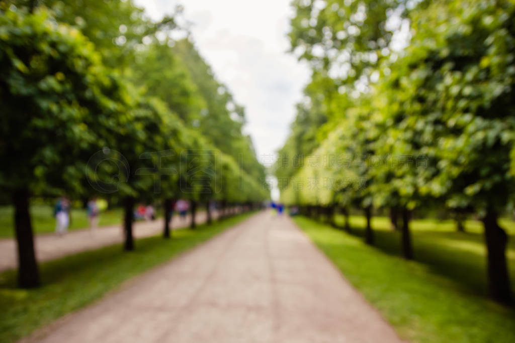 Blurred image of Peterhof, Russia. Tourists walking in the park