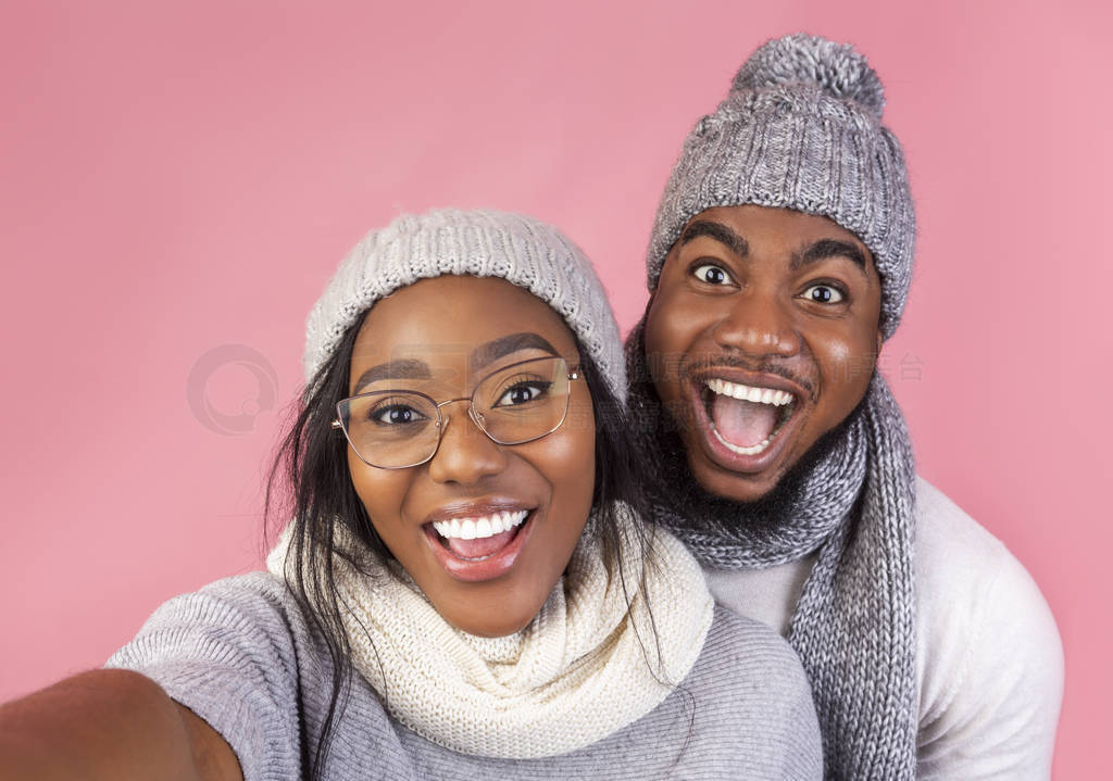 Emotional black winter guy and girl taking selfie together